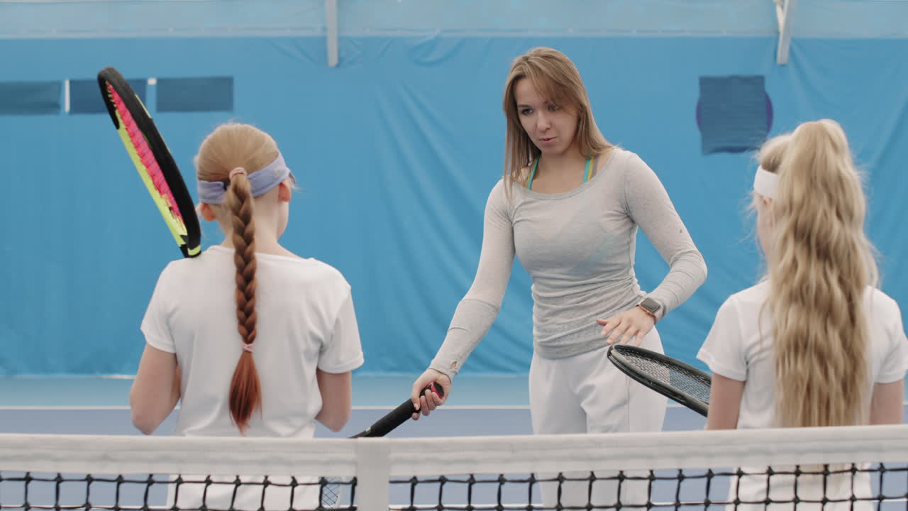 Female Coach And Kids On Tennis Training