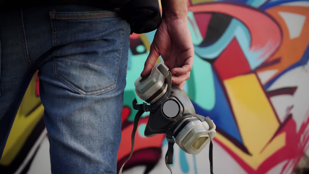 Graffitaro che tiene una maschera protettiva 4k
