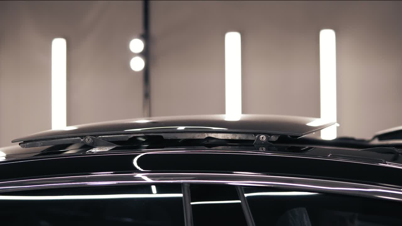 Black car's roof top slides out and opens the pano view.