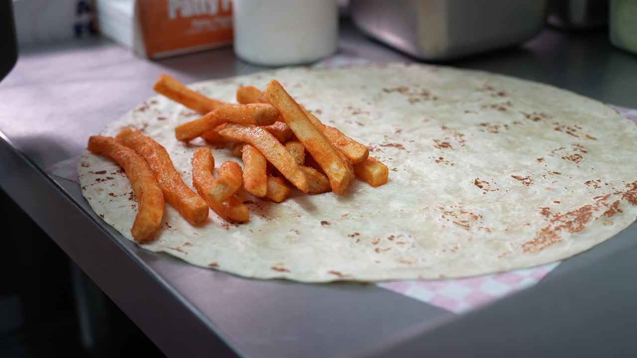 agregar papas fritas mientras se hace un burrito californiano - serie de camiones de comida