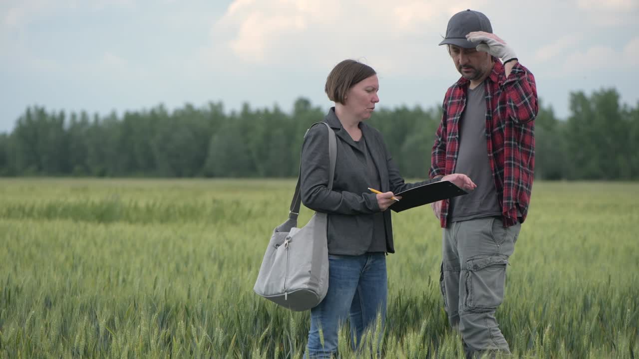 сотрудник по ипотечным кредитам, помогающий фермеру в процессе подачи заявки на получение финансового пособия
