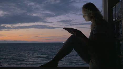 Girl-with-pad-on-outdoor-terrace-in-the-evening