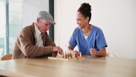 Elderly man playing chess with caregiver