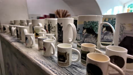 collection of cat-themed mugs on display