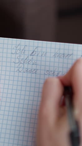 vista de mano en primer plano de la escritura individual en el cuaderno con pluma, mostrando movimientos graciosos de la mano en papel gráfico, capturando detalles del proceso de escritura a mano