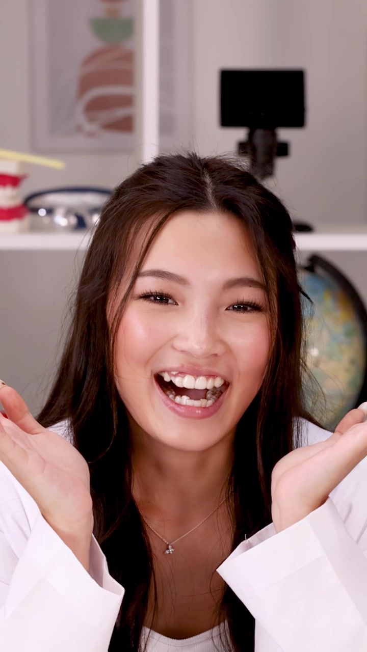 Medium shot of a joyful student in a lab coat laughing in a classroom.