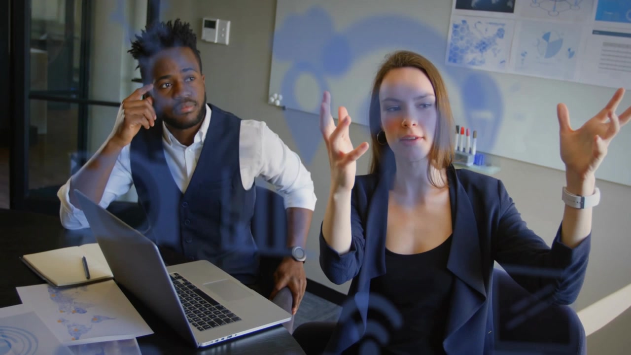 Femme parlant, illustrant un concept lors d'une réunion d'affaires, homme écoutant, superposition bleue sur la scène.