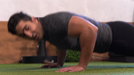 hombre musculoso realizando una variación del clásico ejercicio push-up