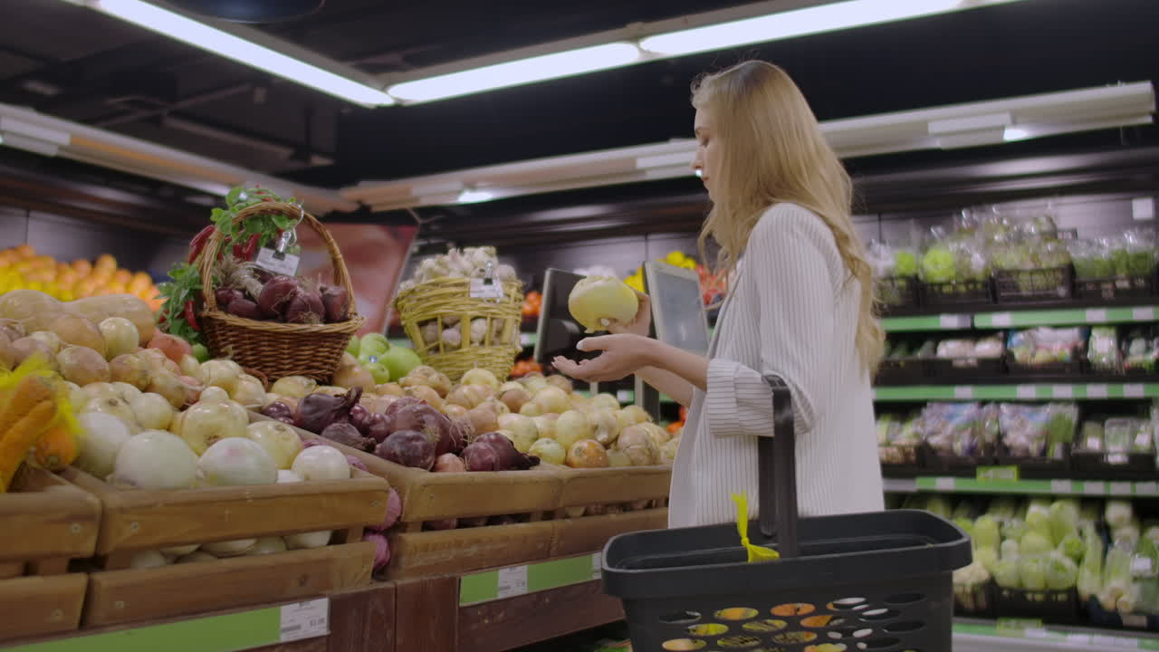 una joven bonita comprando verduras en el mercado.