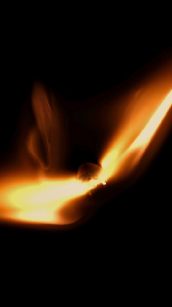 Nærbillede af en tændstik, der antændes og brænder i slowmotion