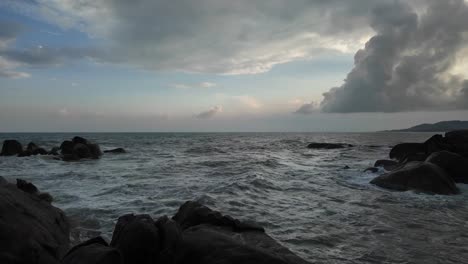scenic view of waves crashing onto rocky beach during summertime