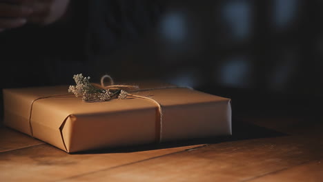 hands wrapping a gift with brown paper and string