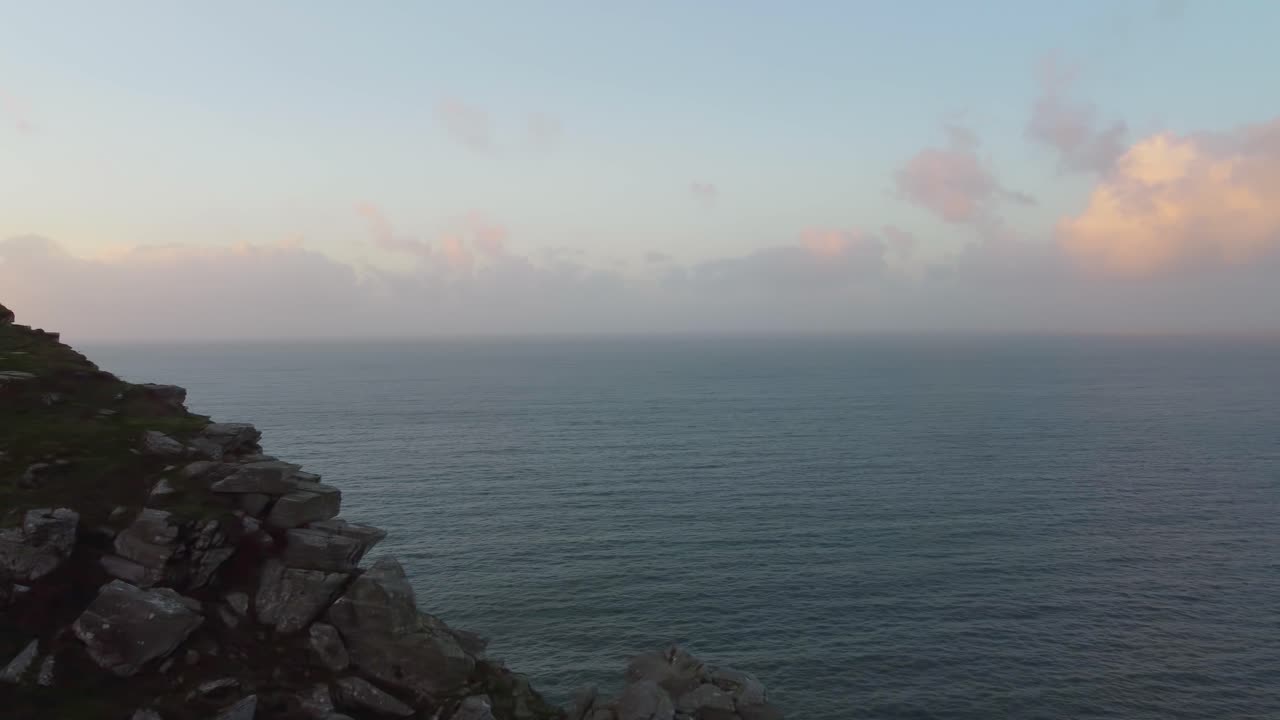 drone aéreo yendo de lado a lo largo de la espectacular cima del acantilado al atardecer en el valle de las rocas en exmoor uk 4k