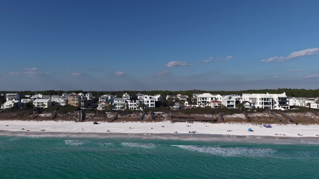 Veduta aerea lontana di una costa con spiaggia sabbiosa nella zona 30A, con moderne case bianche lungo la riva, Florida, USA