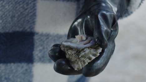 opening a streamed oyster by hand, tight shot