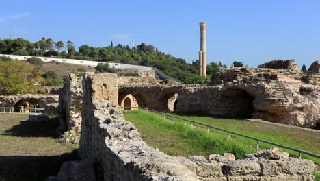 Sunny-day-at-the-ancient-Roman-ruins-in-Carthage,-Tunisia,-with-green-landscape-in-the-background