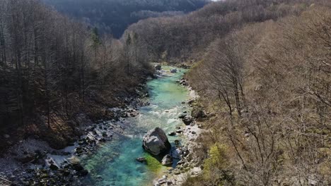 soča river flows in vivid turquoise hues, framed by slovenia's spring landscape.
