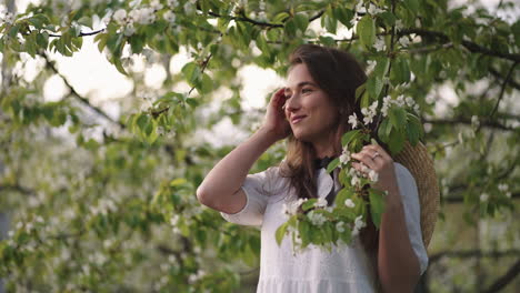 romantic female portrait in blooming garden in spring day happy and inspired woman in white dress