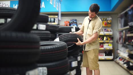 man shopping for tires in an automotive store