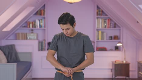 Indian-man-measuring-waist-using-inch-tape