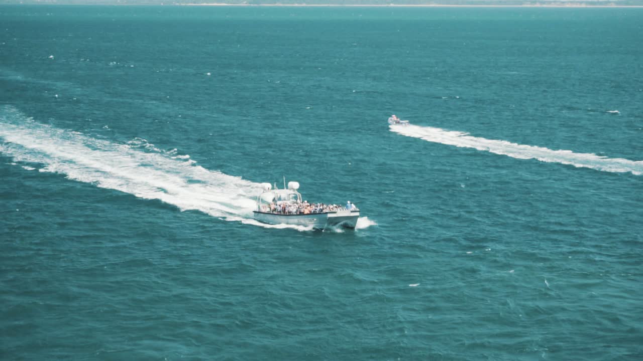 Slow motion shot of speed boats racing through the ocean.