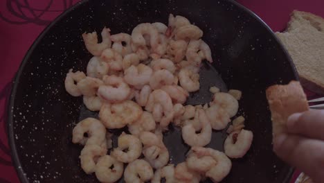 Person-Dips-Bread-in-Spanish-Garlic-Shrimp-Sauce-in-Skillet,-Close-Up