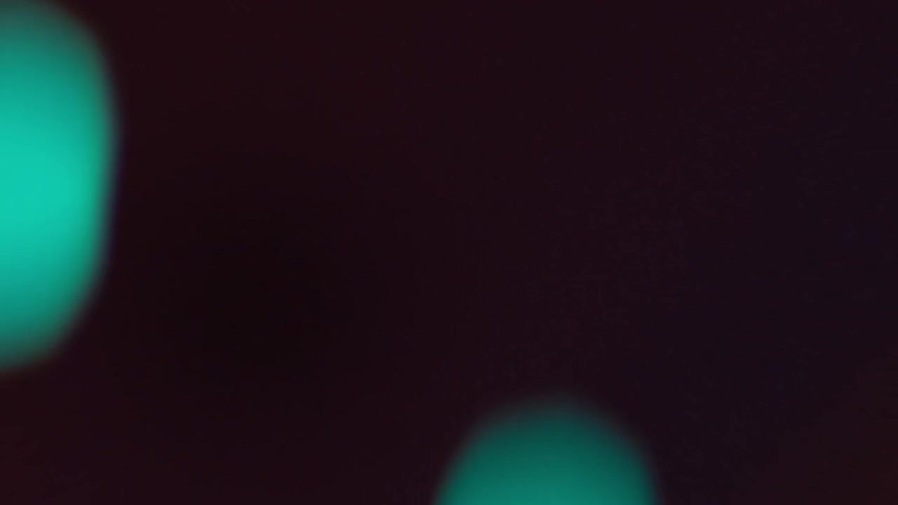 Fughe di luce bokeh colorate e bagliori dell'obiettivo su sfondo scuro
