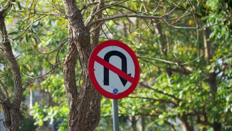 Traffic-sign-U-turn-prohibited-with-trees-on-the-background