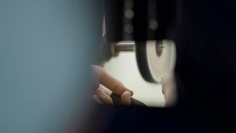 close-up of hands repairing machinery