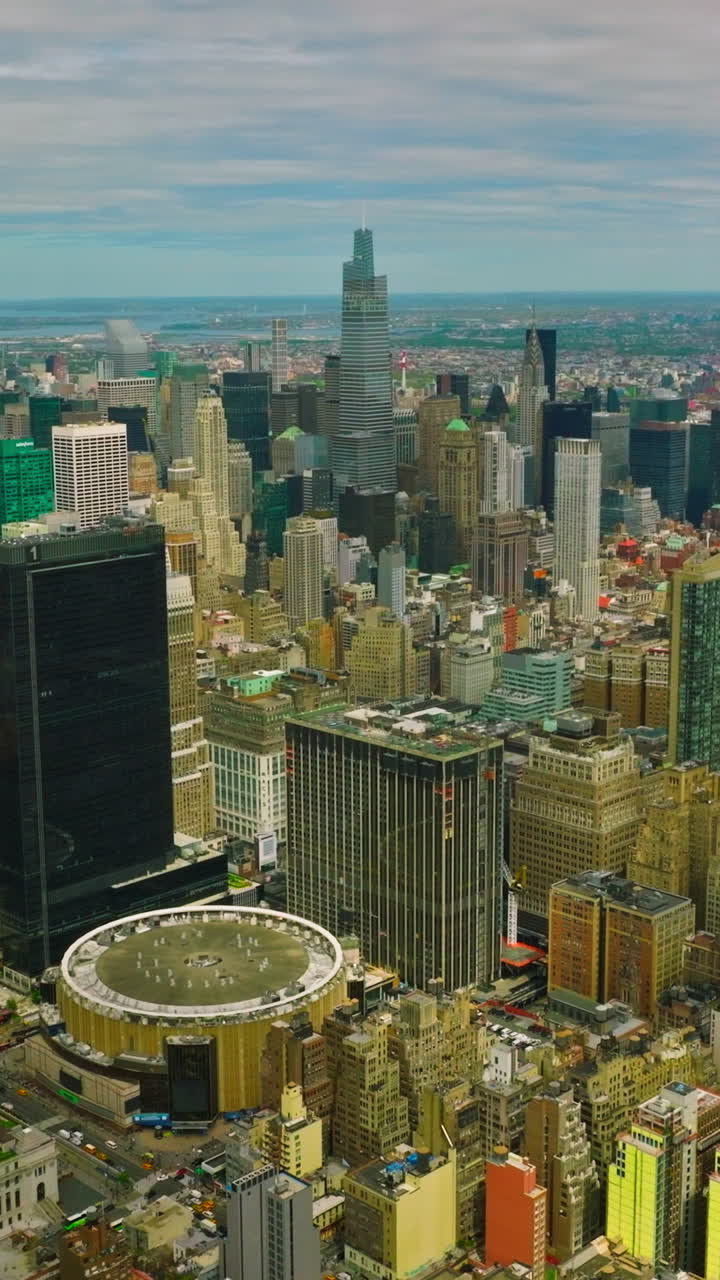 Densely built New York city panorama at daytime. Outstanding metropolis at the backdrop of cloudy sky. Vertical video