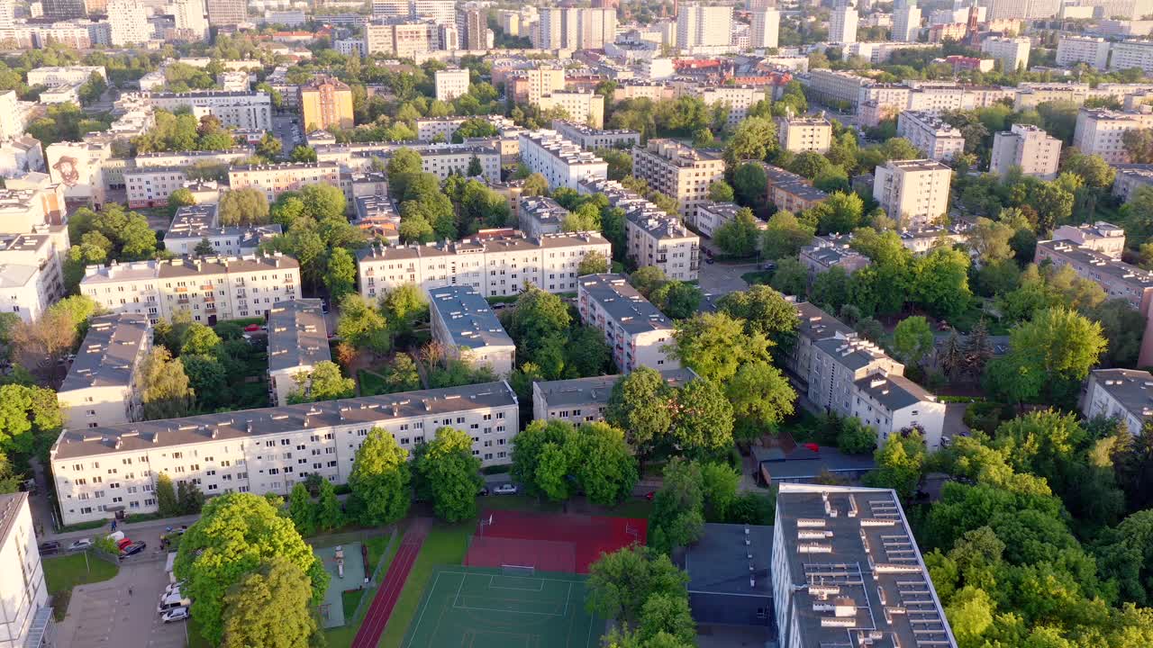 Aerial sunset view of Warsaw Wola district with green trees and residential blocks