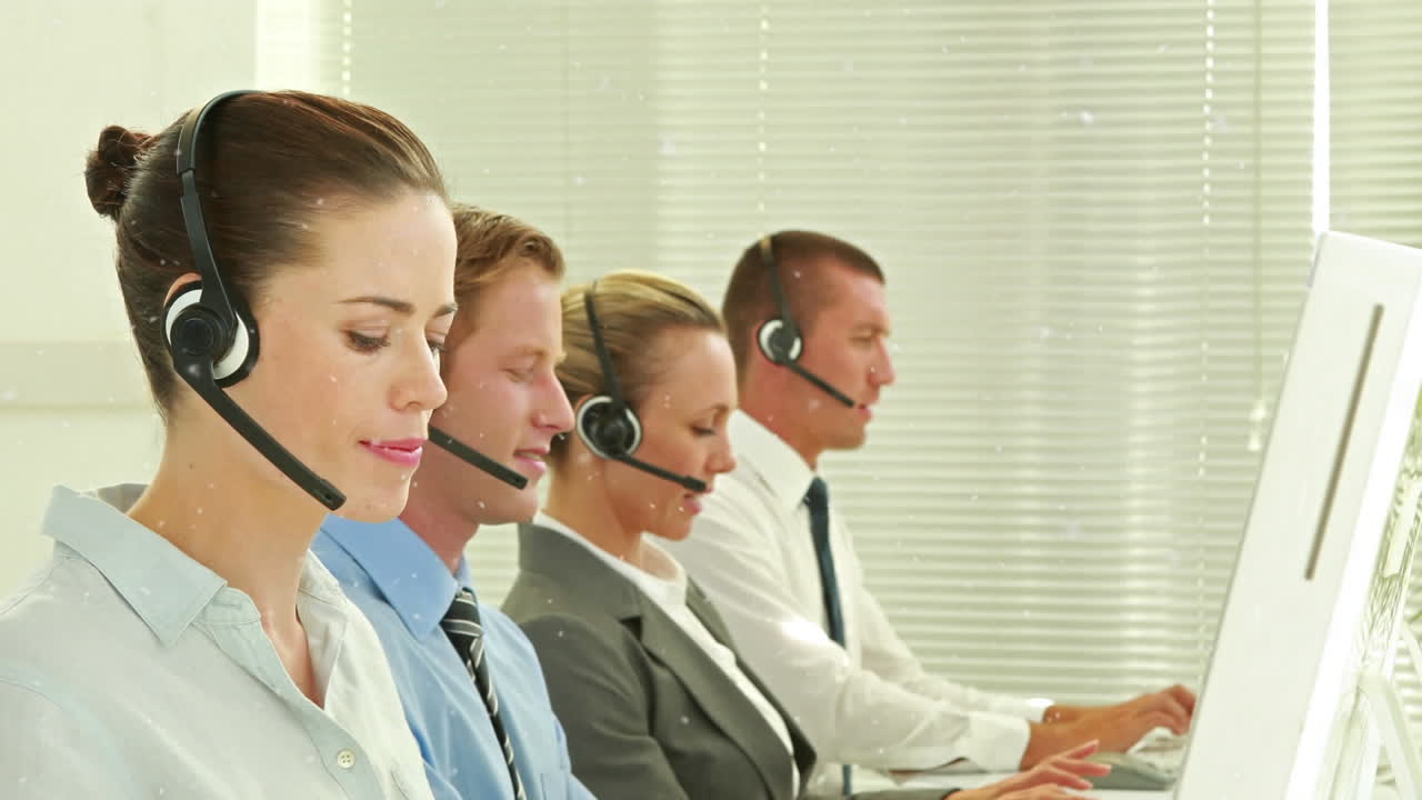 animación de la nevada sobre los representantes de servicio al cliente caucásicos que trabajan en la computadora en la oficina
