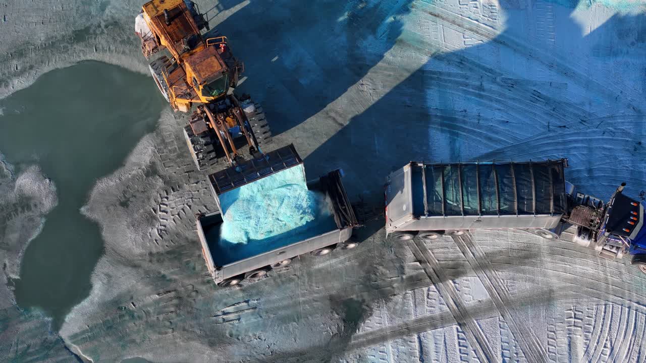 Top-Down View of Loader Dumping Blue Salt into Truck Trailer at Detroit Depot, USA