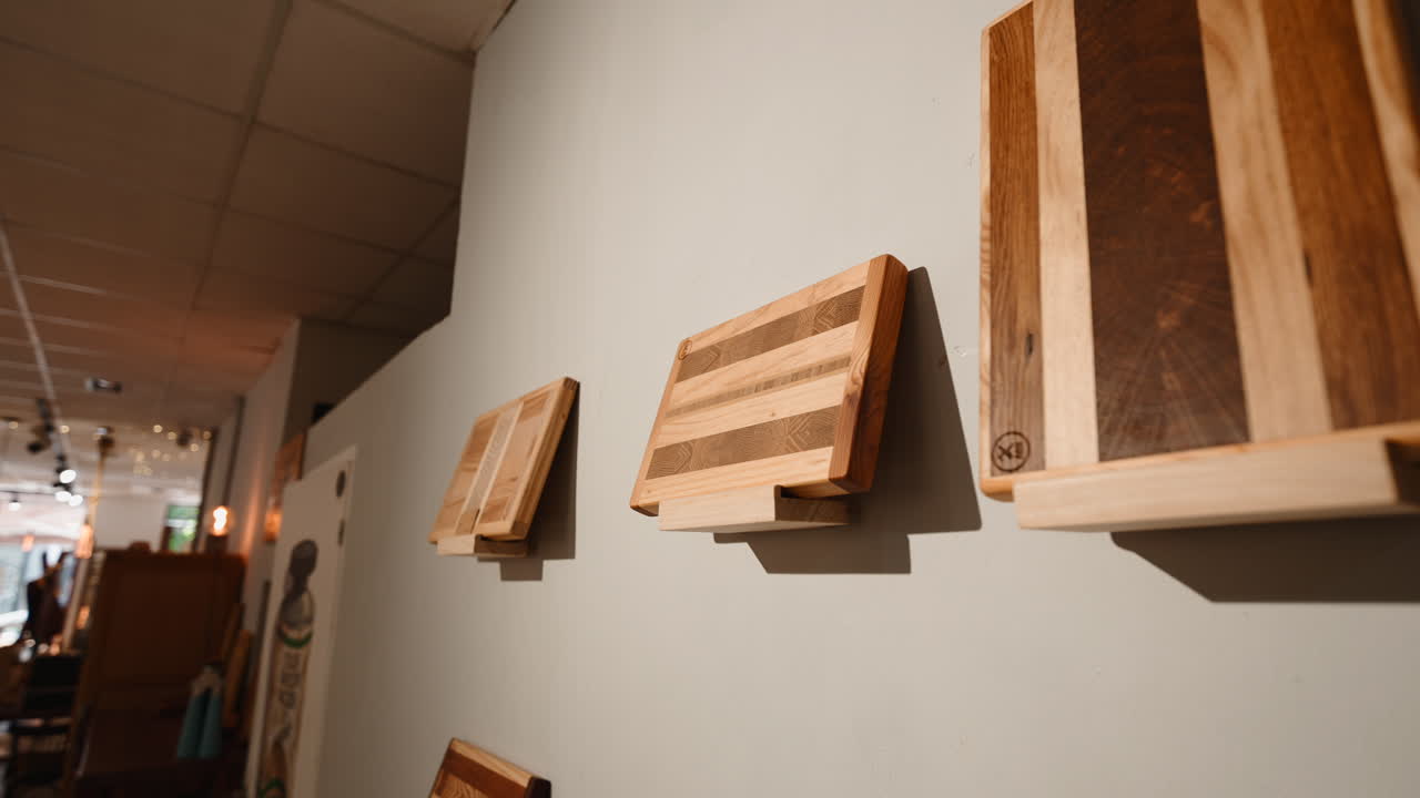 Collezione di taglieri in legno fatti a mano esposti su una parete