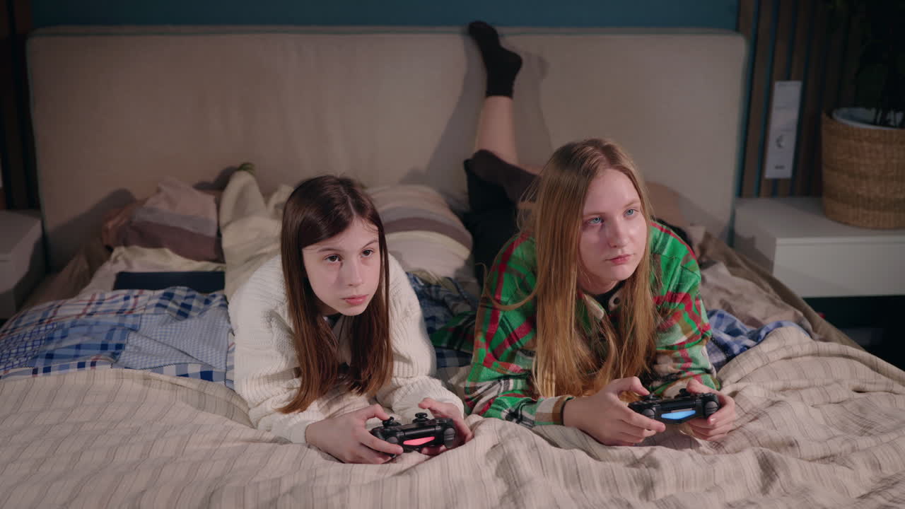 Ragazze adolescenti che giocano ai videogiochi in camera da letto