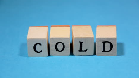 Composing-the-word-Cold-with-wooden-letters-on-a-light-blue-background