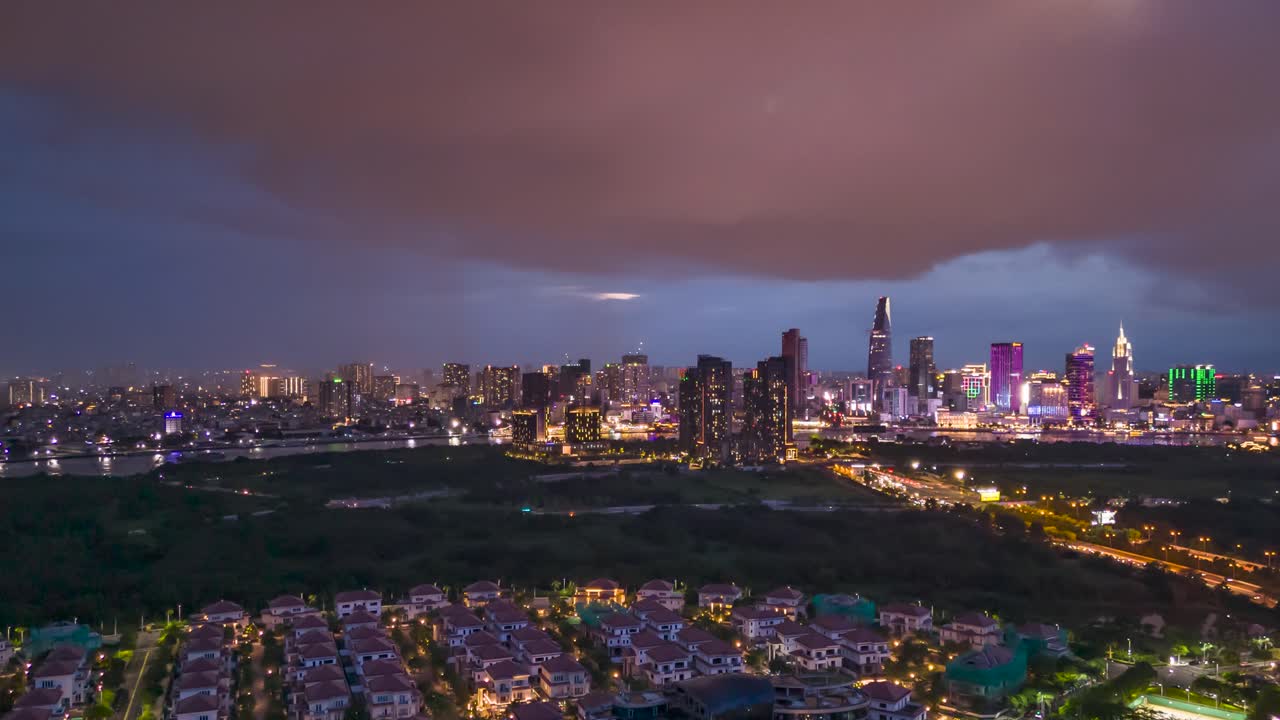 hyperlapse nocturno aéreo del horizonte de la ciudad de ho chi minh y la tormenta de sala, un desarrollo moderno y lujoso con parque y lago cerca del río saigon