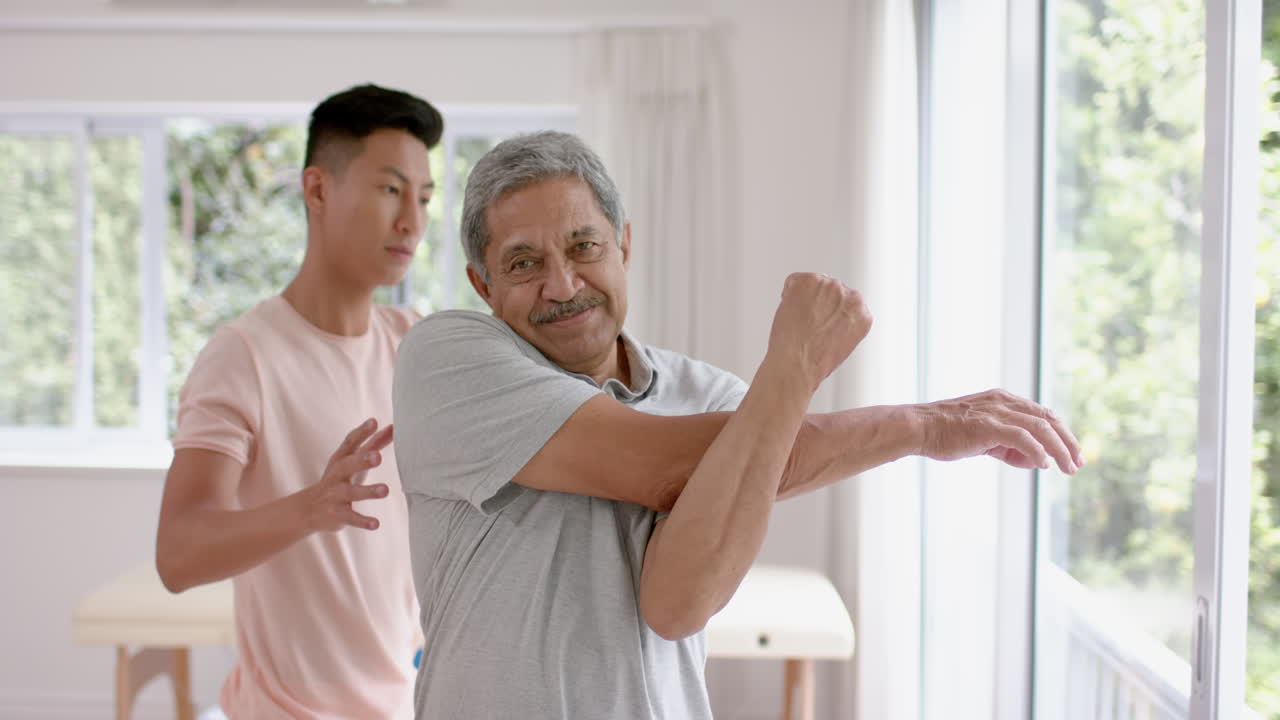 Senior biracial man receives physical therapy at home, with copy space