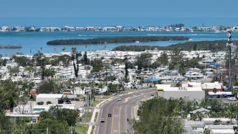 cars on main street in cortez, florida. aerial wide shot. sunny day in american town with islands. bradenton beach in background. summer day with turquoise bay lagoon.