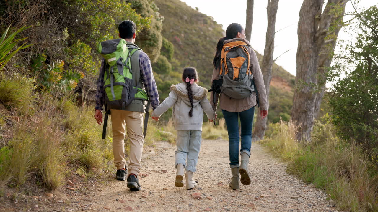 familia feliz, caminando y tomándose de la mano al aire libre