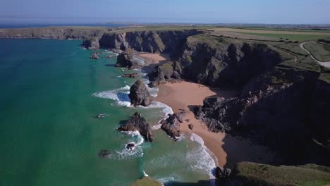 Scenic-Aerial-View-Over-Bedruthan-Steps-with-Turquoise-Seaside-Along-the-Rocky-Cornish-Coastline-in-Cornwall,-England,-UK