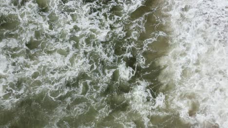 overhead shot of beautiful waves crashing on sandy beach, california