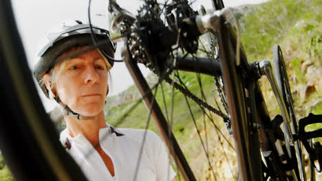 senior cyclist checking bicycle at countryside 4k