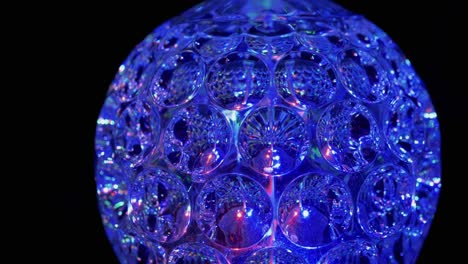 spinning led disco ball glowing neon lights in dark. close-up. 4k