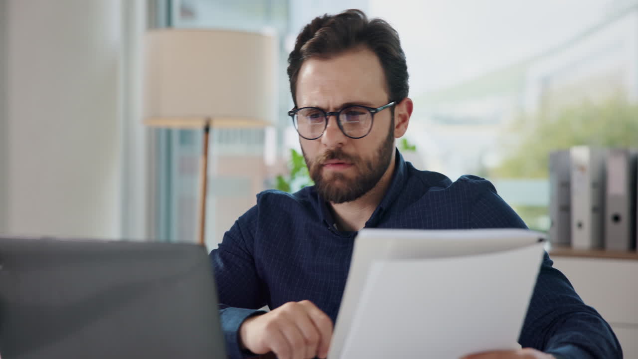 Man Reading Paperwork in Office