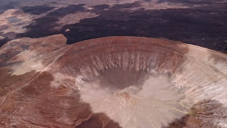 Impressive aerial drone footage of Caldera Blanca, the largest volcanic crater in Lanzarote, Canary Islands, Spain.