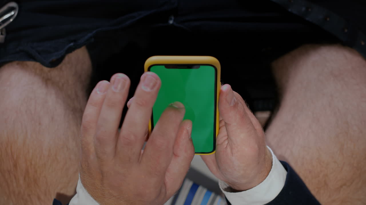 hombre sosteniendo un teléfono con pantalla verde