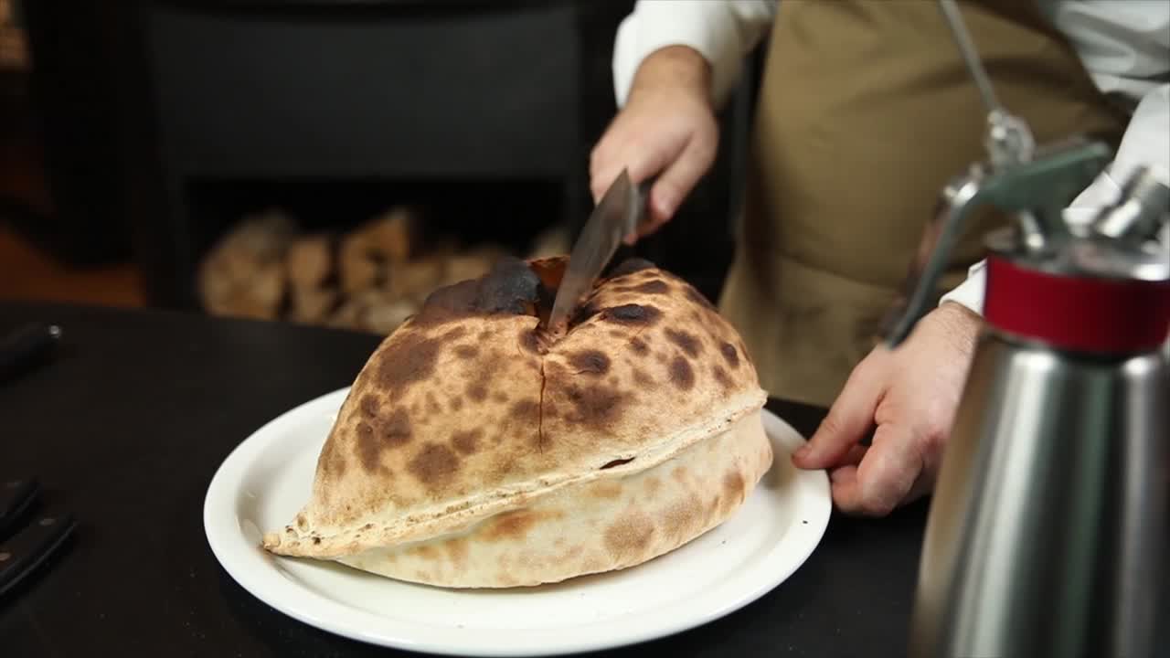 el chef cortando un calzone grande