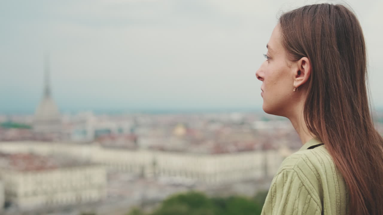 Young Woman Looks at City View and Turns to Camera