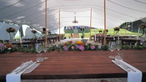 wide dolly shot of boho decorated newlyweds wedding table with flower creation